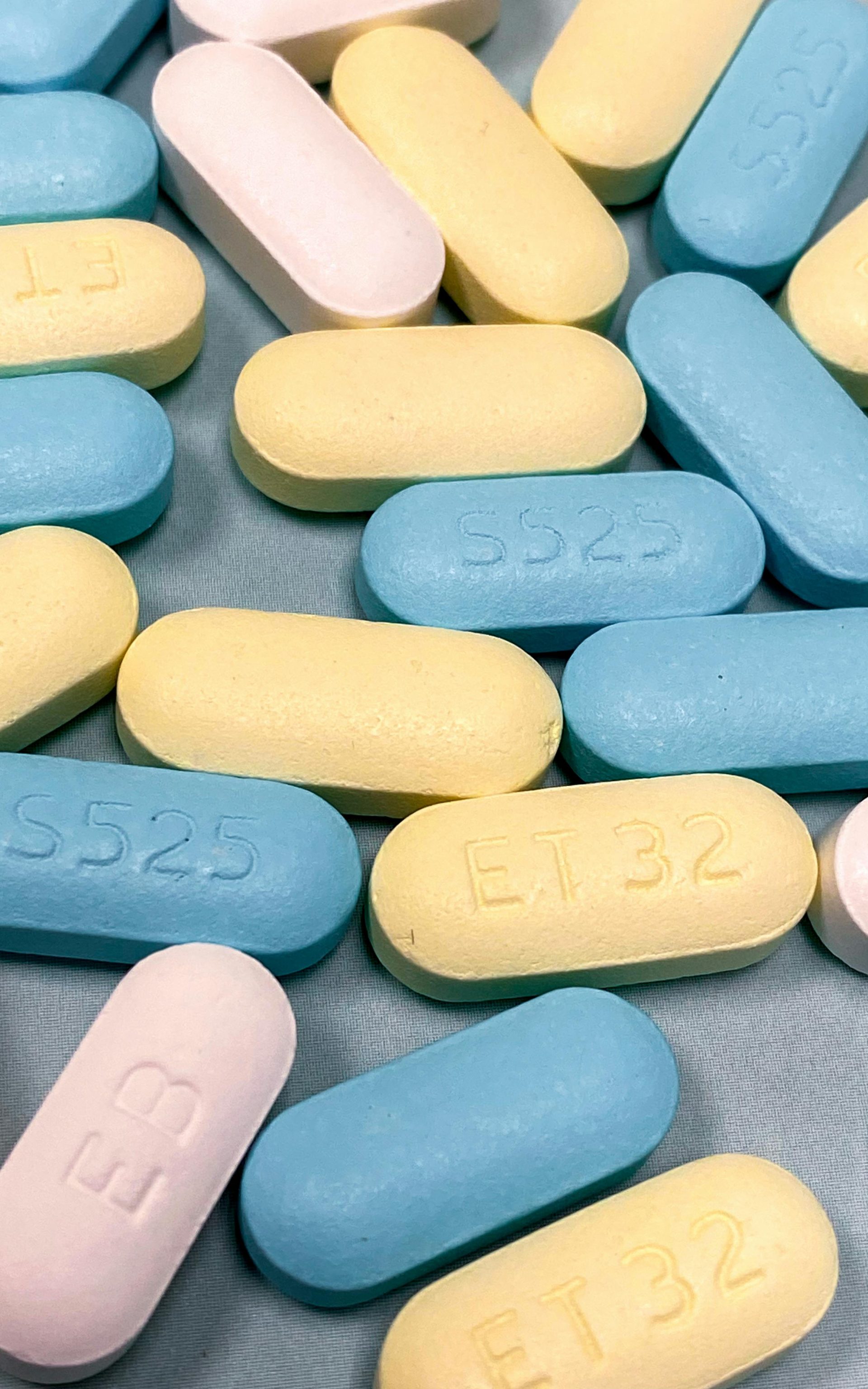 Close-up of assorted colorful medicine tablets scattered on a surface.